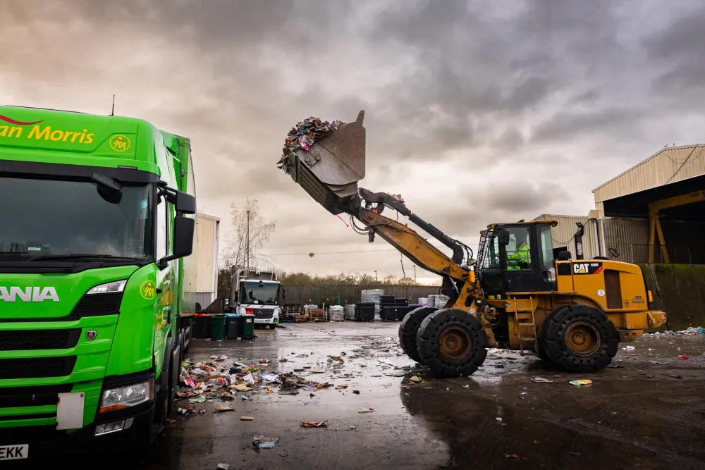 A JCB loads a HGV with recycling